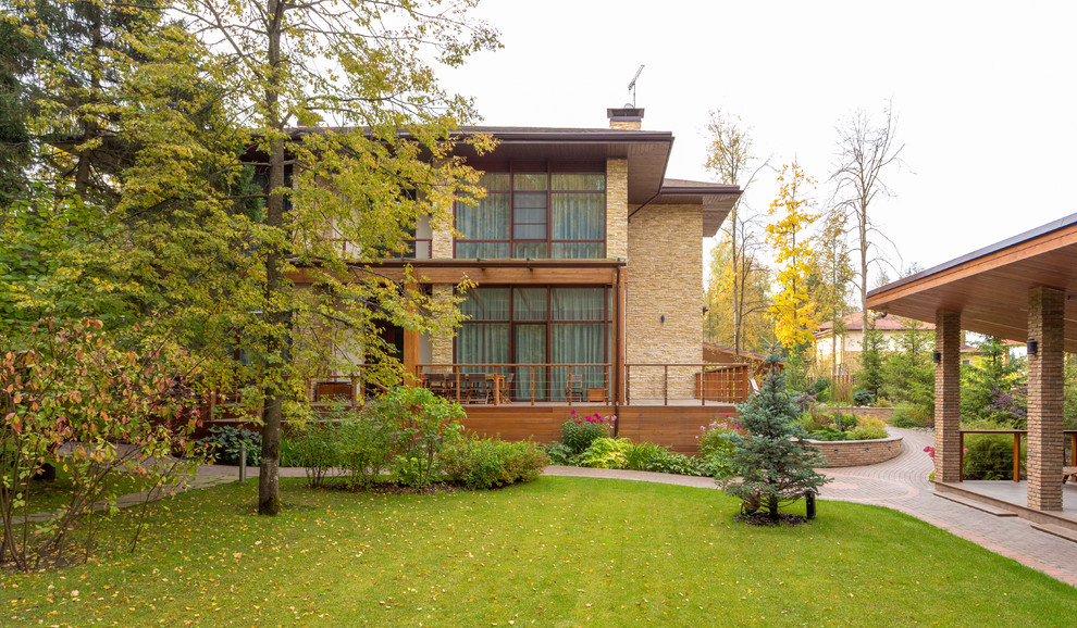 Foto de fachada de casa beige y marrón urbana grande de dos plantas con revestimientos combinados, tejado plano, tejado de teja de madera y panel y listón