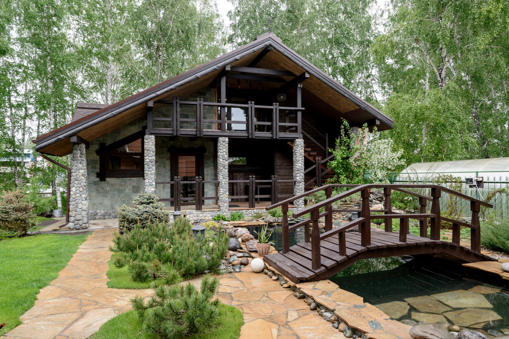 Foto de fachada de casa nórdica grande de dos plantas con revestimiento de piedra y tejado a dos aguas