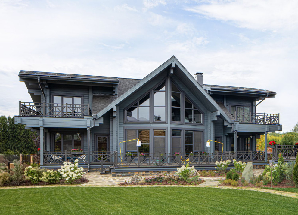 Inspiration pour une grande façade de maison grise design en bois à un étage avec un toit à deux pans.