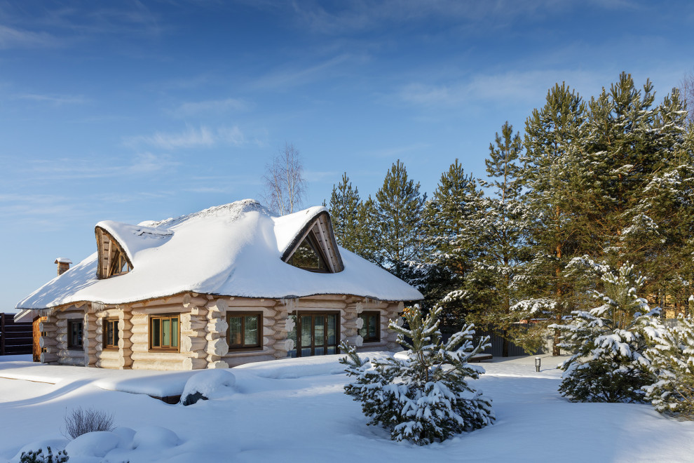 Ejemplo de fachada de casa beige rural grande de dos plantas con revestimiento de madera y techo verde