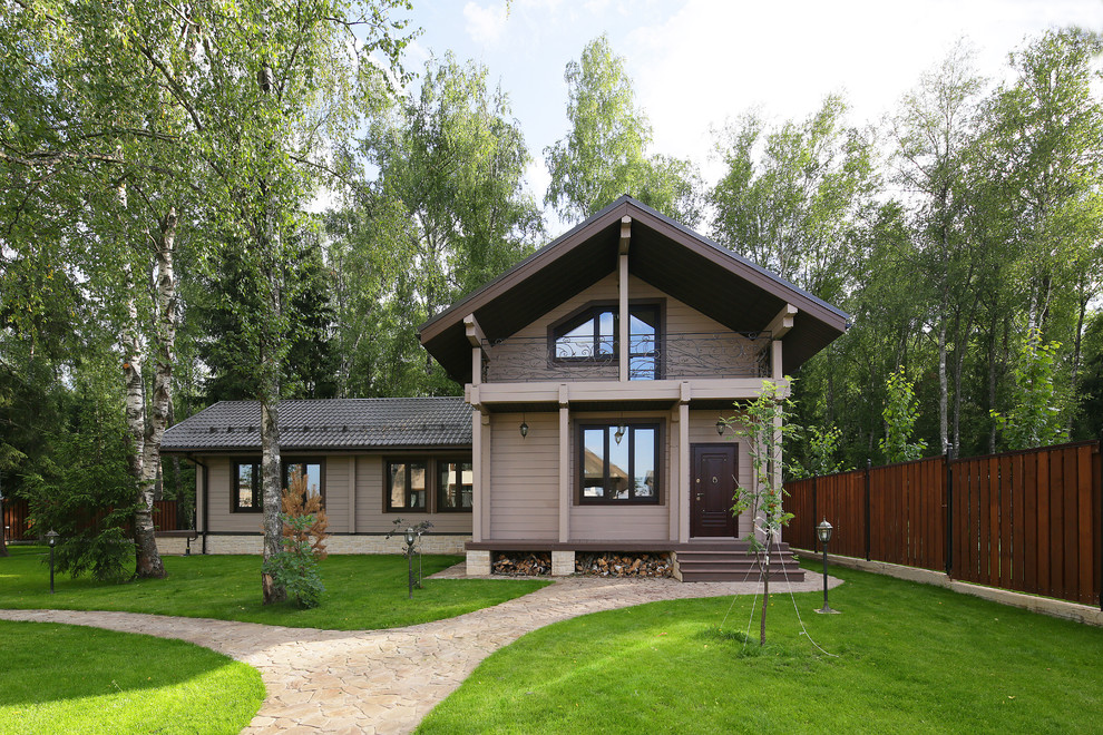 На фото: двухэтажный, деревянный, серый частный загородный дом среднего размера в стиле кантри с двускатной крышей с