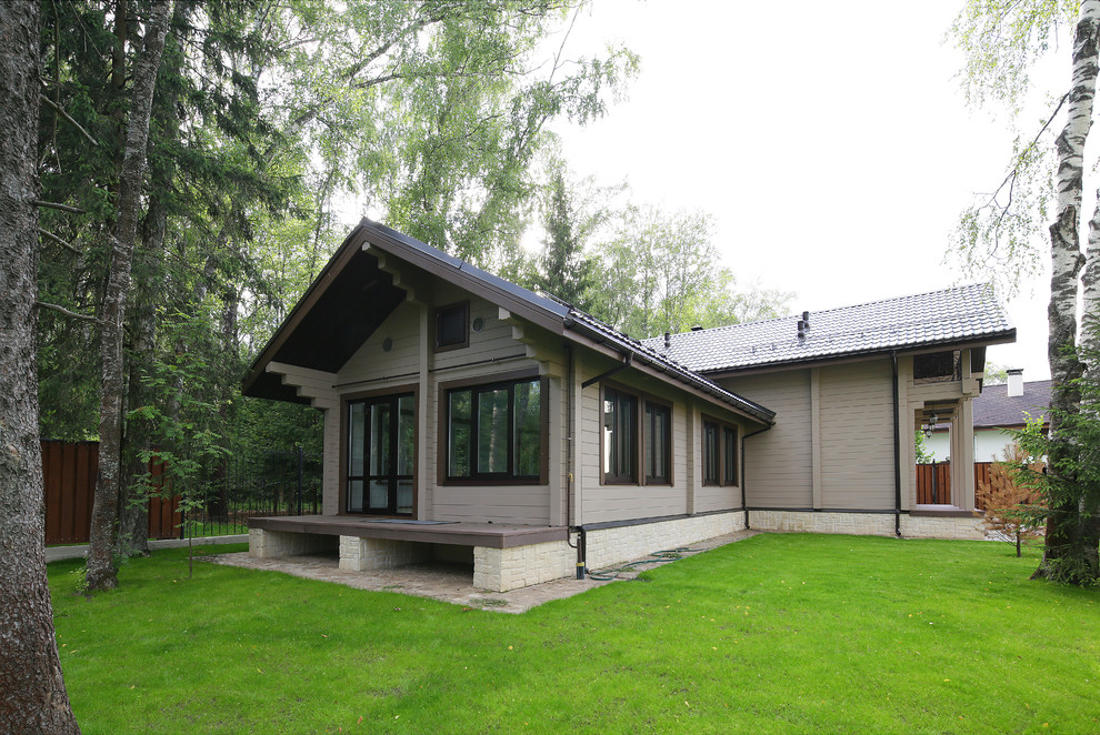 Exempel på ett mellanstort lantligt grått hus, med sadeltak