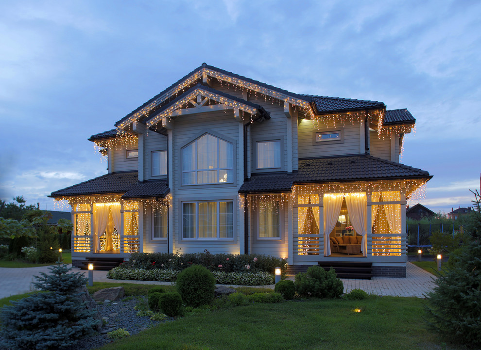 Стильный дизайн: большой, двухэтажный, деревянный, серый частный загородный дом с черепичной крышей - последний тренд
