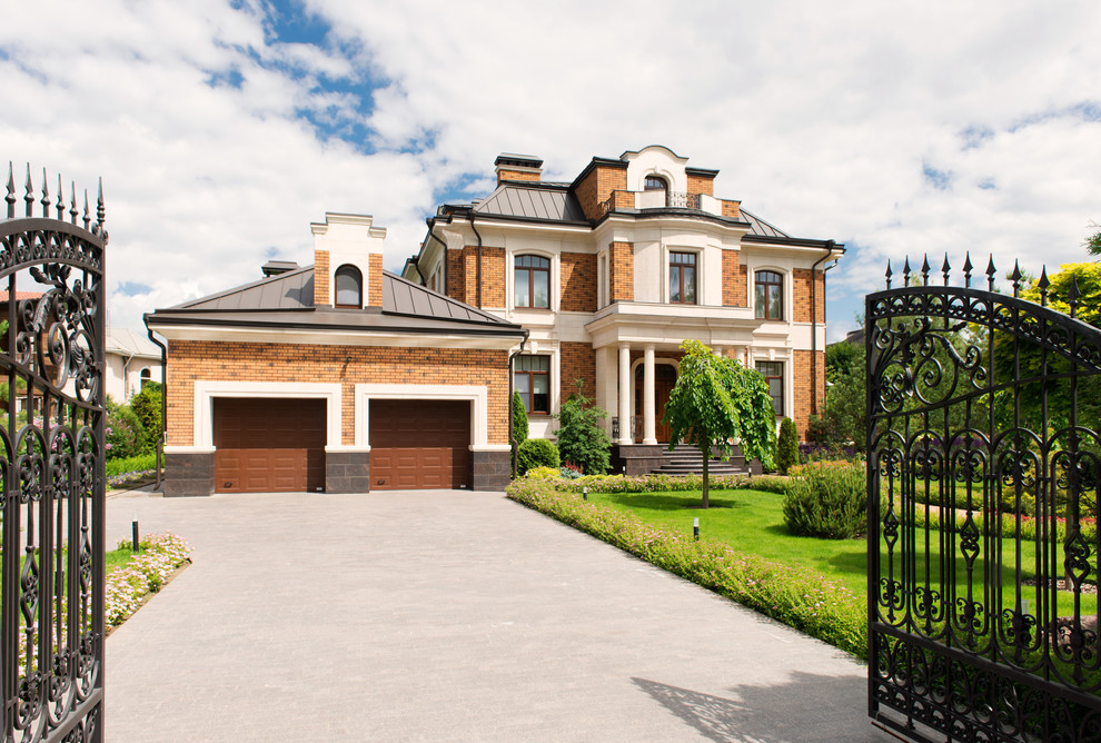 Large elegant multicolored split-level brick house exterior photo in Moscow with a gambrel roof and a metal roof