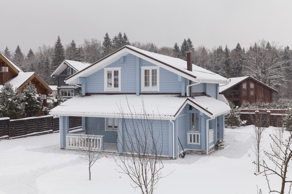 Blue scandinavian two floor detached house in Moscow with wood cladding and a pitched roof.