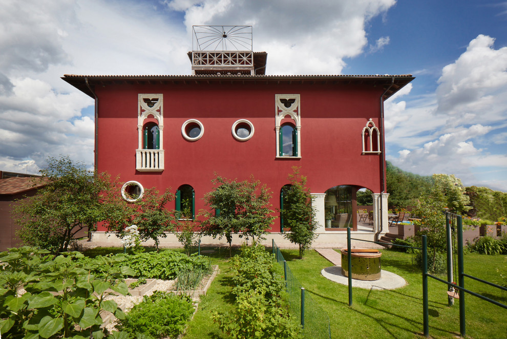 Imagen de fachada de casa roja tradicional renovada pequeña de dos plantas con revestimiento de estuco y tejado de teja de barro