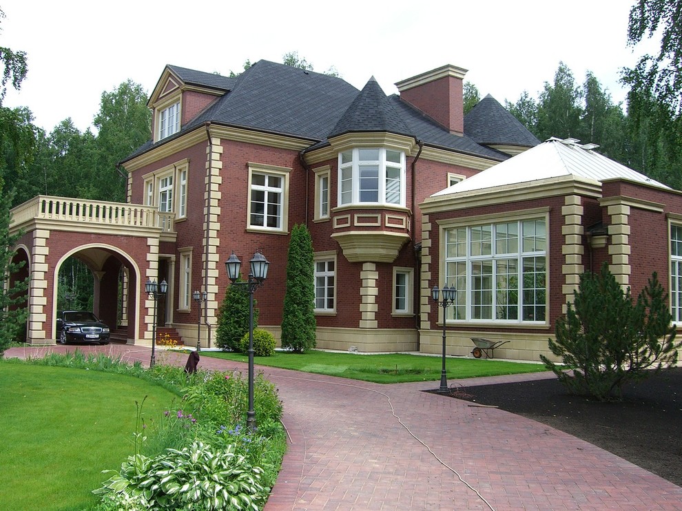 Immagine della facciata di una casa marrone classica a tre piani con rivestimento in mattoni