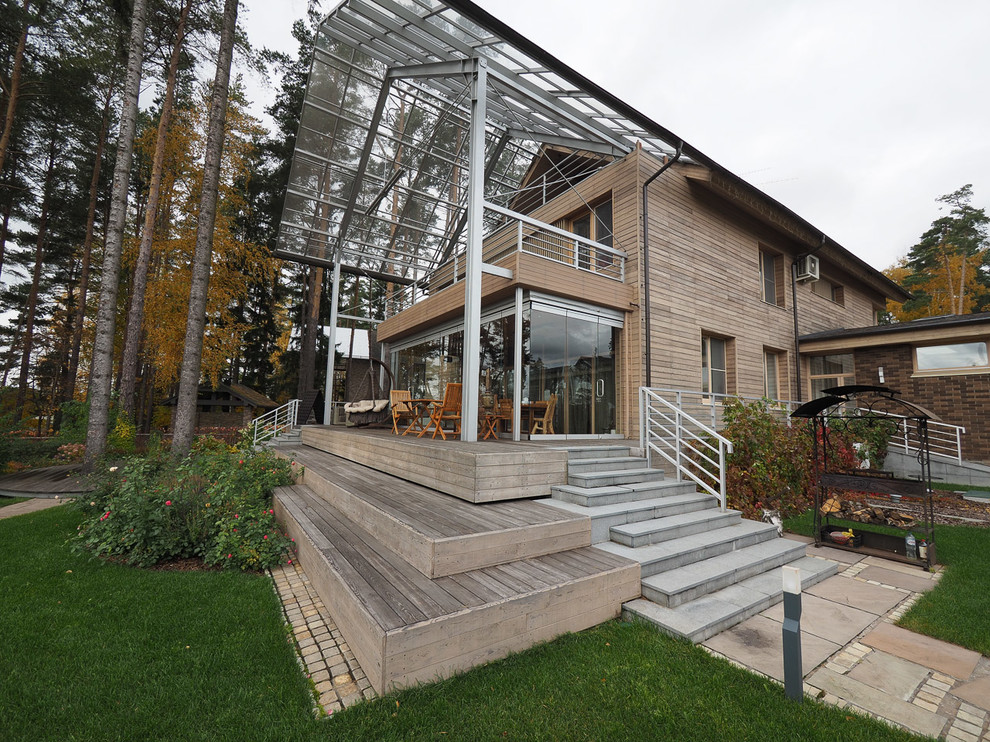 Ejemplo de fachada de casa beige contemporánea de tamaño medio de dos plantas con revestimiento de madera, tejado a dos aguas y tejado de teja de madera