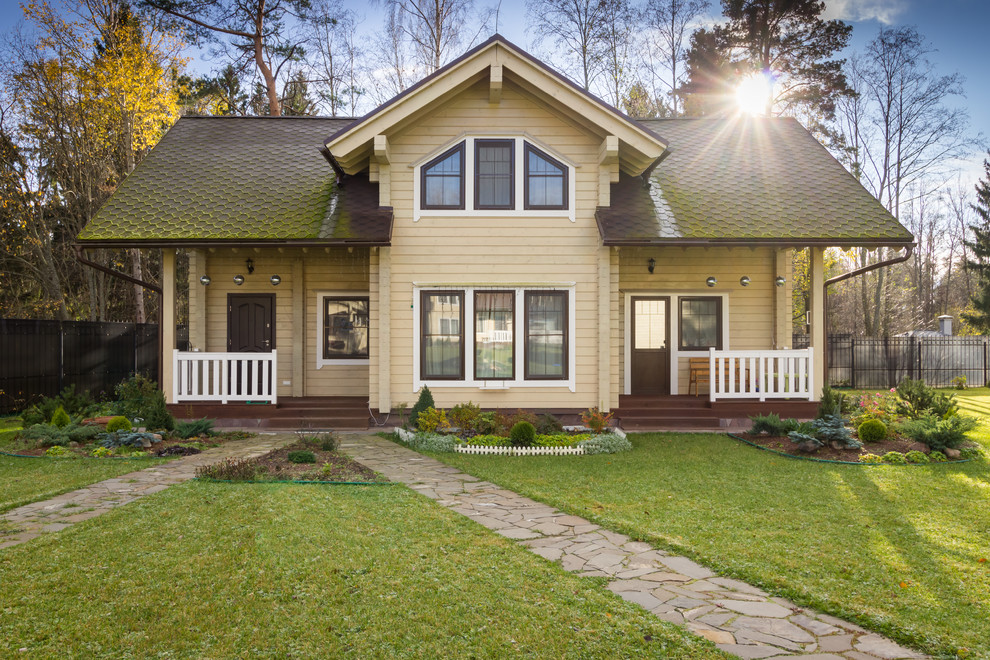 Modelo de fachada de casa bifamiliar beige tradicional de dos plantas con revestimiento de madera y tejado a dos aguas