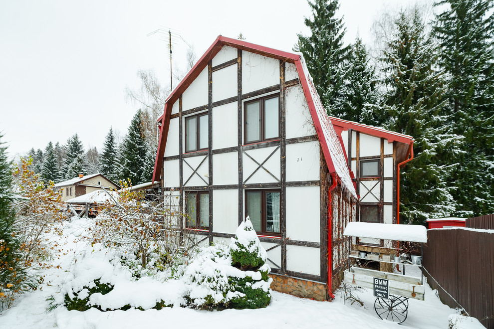 Idée de décoration pour une grande façade de maison blanche chalet en stuc à un étage avec un toit de Gambrel et un toit en shingle.