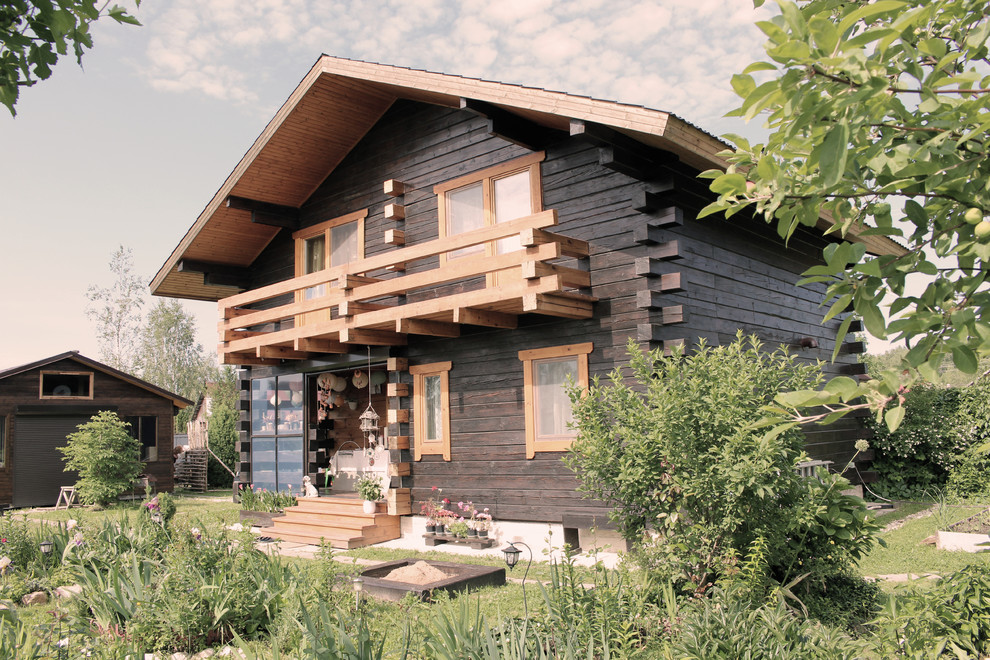Стильный дизайн: двухэтажный, деревянный, коричневый частный загородный дом среднего размера в стиле кантри с двускатной крышей и металлической крышей - последний тренд