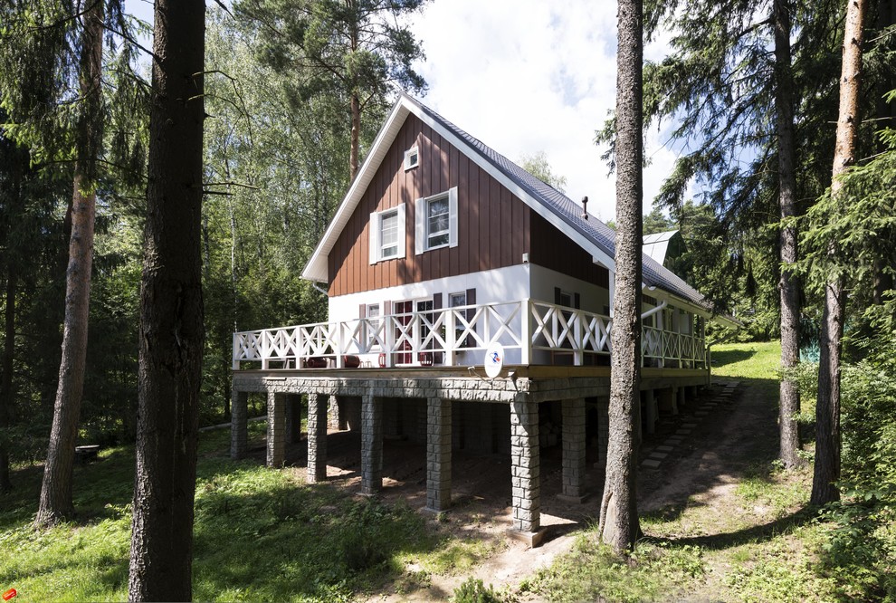 На фото: двухэтажный, белый дом среднего размера в скандинавском стиле с комбинированной облицовкой и двускатной крышей