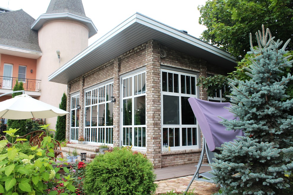 Стильный дизайн: маленький, одноэтажный, коричневый дом в современном стиле с облицовкой из камня и односкатной крышей для на участке и в саду - последний тренд