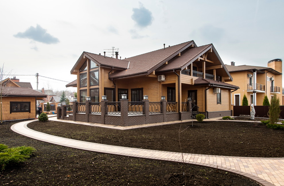 Mittelgroße, Zweistöckige Nordische Holzfassade Haus mit brauner Fassadenfarbe und Satteldach in Moskau