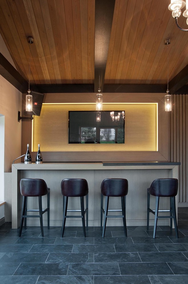 На фото: параллельный домашний бар в современном стиле с полом из сланца, серым полом, барной стойкой, бежевыми фасадами, деревянной столешницей, бежевым фартуком и фартуком из дерева