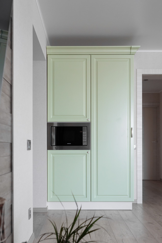 Design ideas for a medium sized traditional u-shaped breakfast bar in Moscow with a submerged sink, raised-panel cabinets, green cabinets, granite worktops, grey splashback, stone tiled splashback, marble flooring and beige floors.