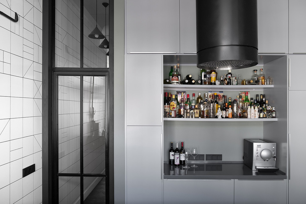 Cette image montre un bar de salon design avec un placard à porte plane et des portes de placard grises.