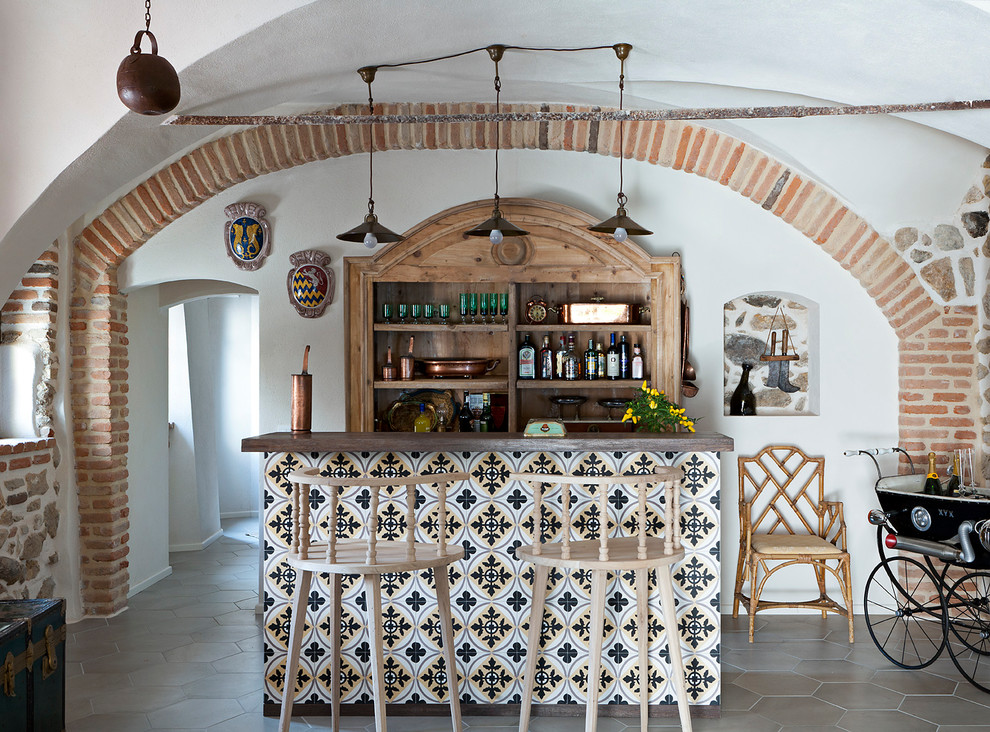 Idee per un bancone bar country di medie dimensioni con ante in legno scuro, top in legno, pavimento con piastrelle in ceramica, pavimento grigio e top marrone