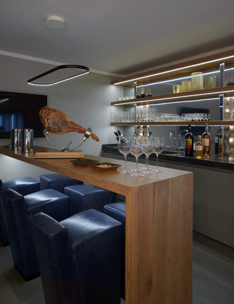 Diseño de bar en casa con fregadero lineal contemporáneo con armarios con paneles lisos, puertas de armario grises y encimeras negras