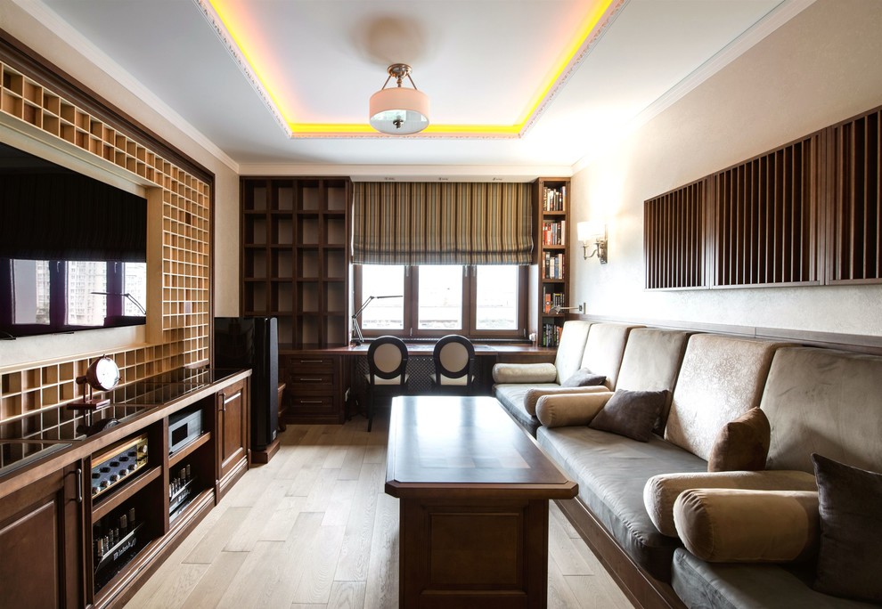 Diseño de cine en casa cerrado tradicional renovado de tamaño medio con paredes beige, suelo de madera en tonos medios, suelo marrón y televisor colgado en la pared