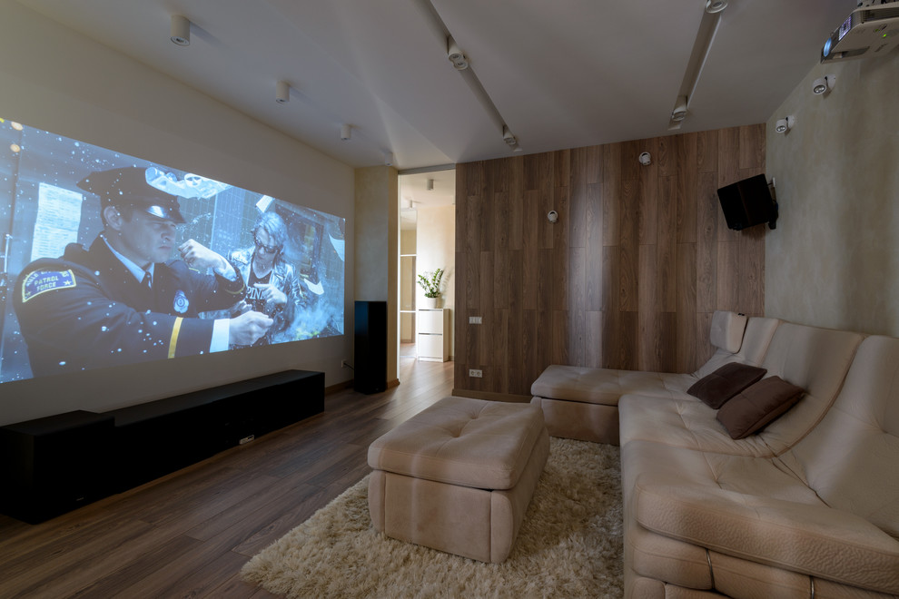 Inspiration pour une grande salle de cinéma design fermée avec un sol en bois brun et un écran de projection.