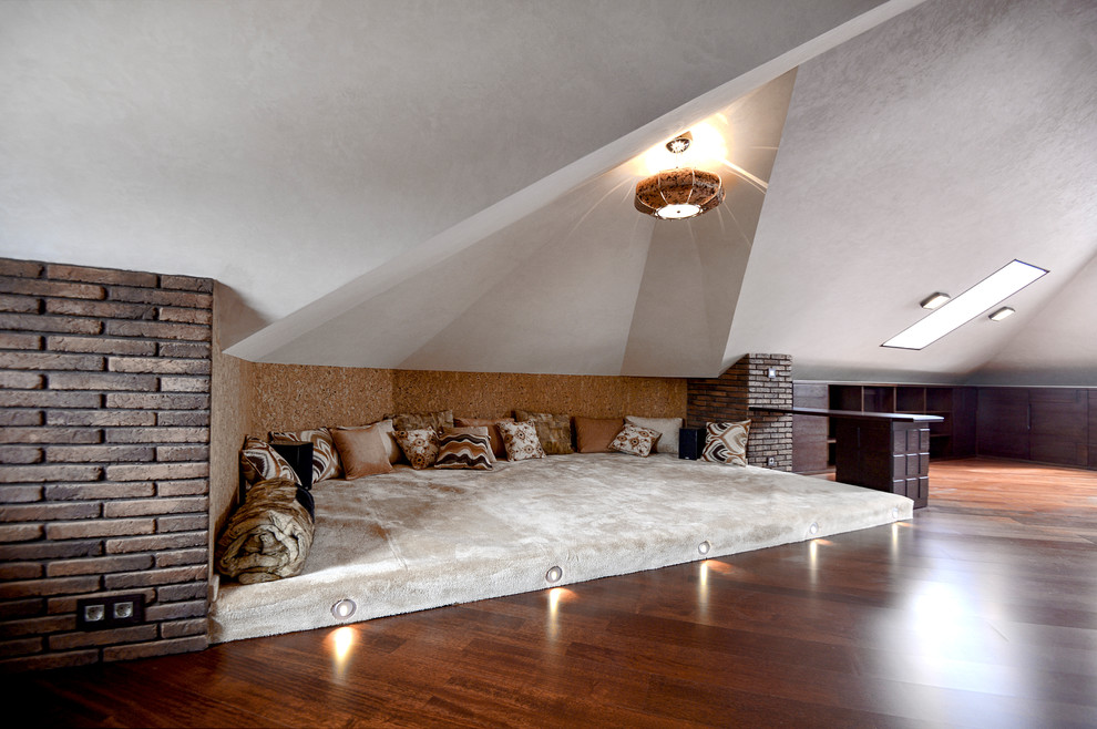 Modelo de cine en casa cerrado bohemio grande con paredes beige, suelo de madera en tonos medios, pared multimedia y suelo marrón