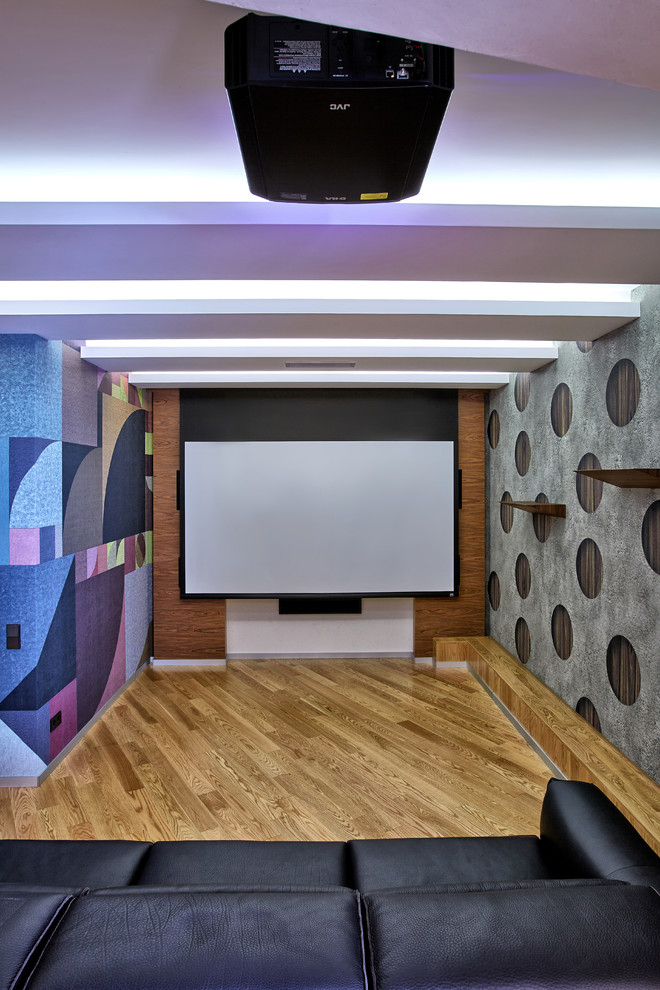 Foto de cine en casa contemporáneo con paredes multicolor, suelo de madera en tonos medios y pantalla de proyección