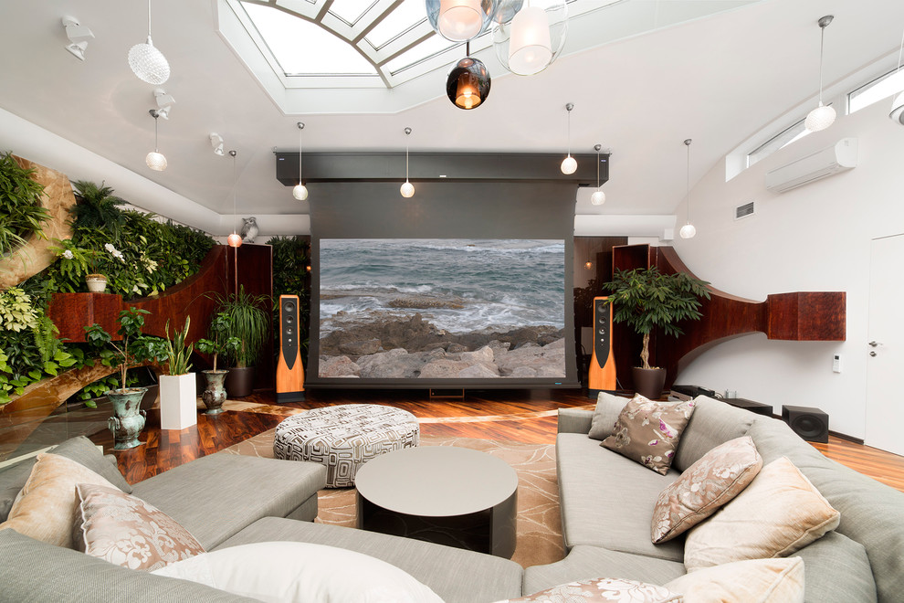 На фото: изолированный домашний кинотеатр в стиле фьюжн с белыми стенами, паркетным полом среднего тона и проектором