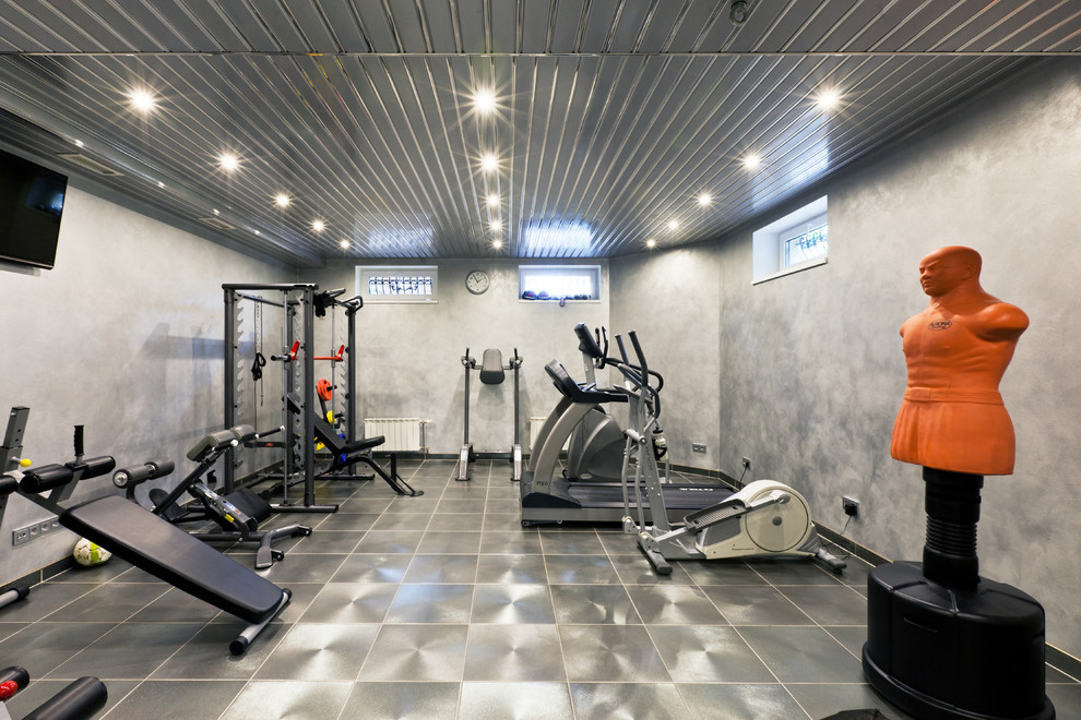 Cette photo montre une salle de musculation tendance de taille moyenne avec un mur gris.