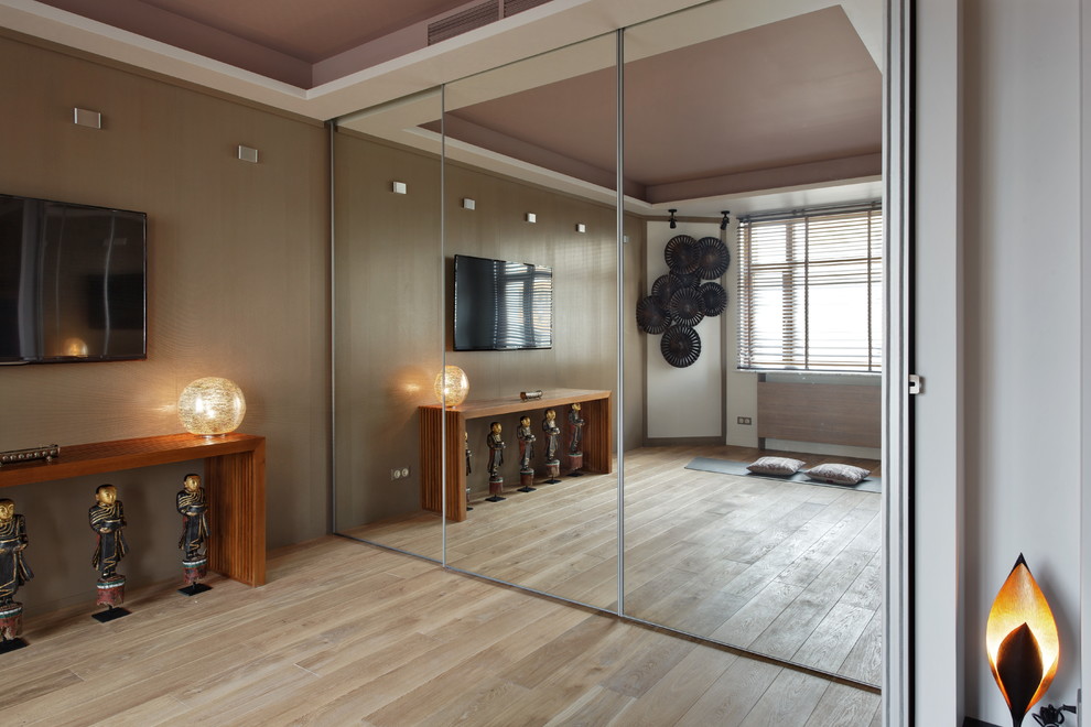 Bild på ett eklektiskt hemmagym med yogastudio, med beige väggar och ljust trägolv