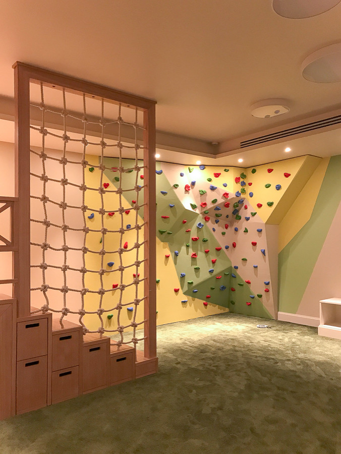 На фото: скалодром среднего размера в стиле неоклассика (современная классика) с разноцветными стенами, ковровым покрытием и зеленым полом