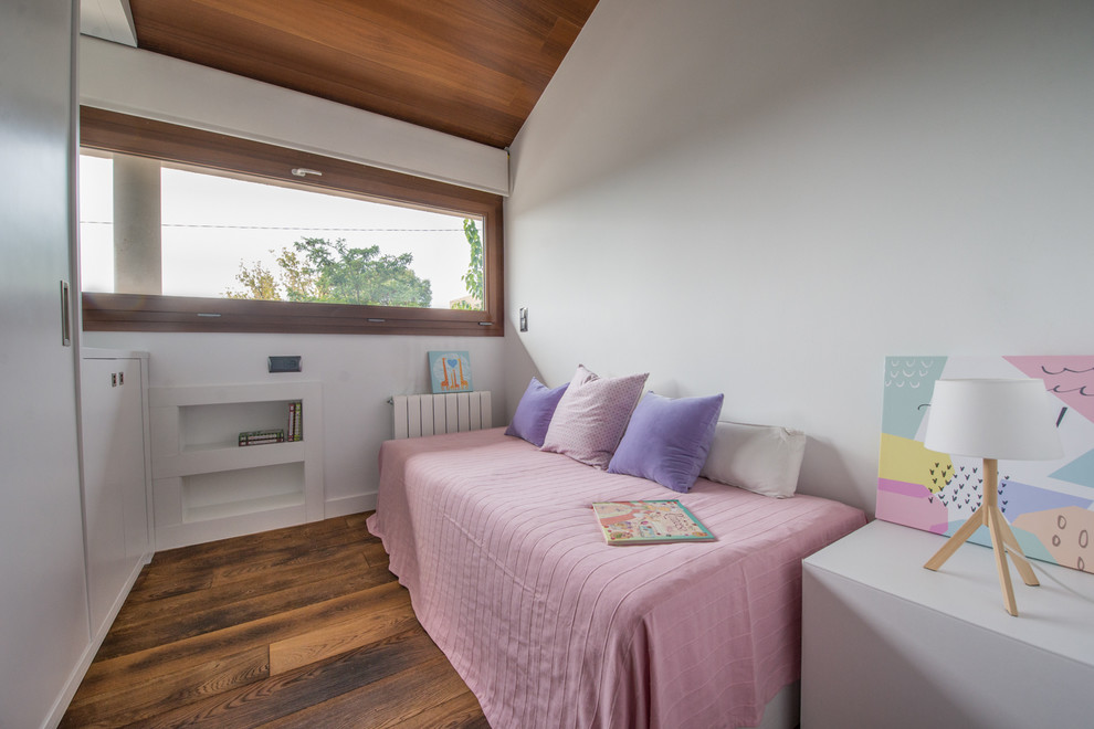 Esempio di una cameretta per bambini da 4 a 10 anni nordica di medie dimensioni con pareti bianche e pavimento in legno massello medio