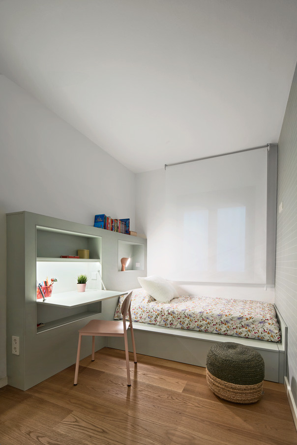 Cette image montre une chambre d'enfant de 4 à 10 ans design de taille moyenne avec un mur blanc et un sol en bois brun.