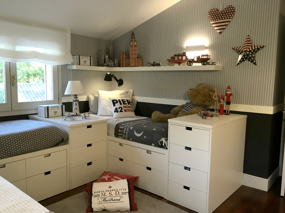This is an example of a large classic children’s room for boys in Barcelona with blue walls and dark hardwood flooring.