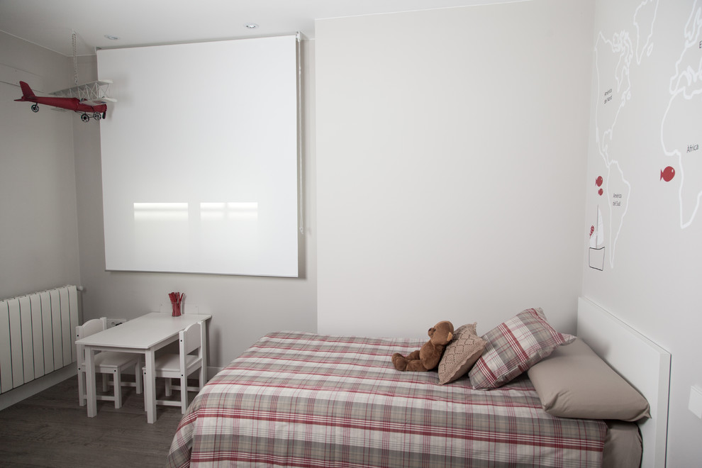 Imagen de dormitorio infantil de 4 a 10 años actual de tamaño medio con paredes blancas y suelo de madera en tonos medios