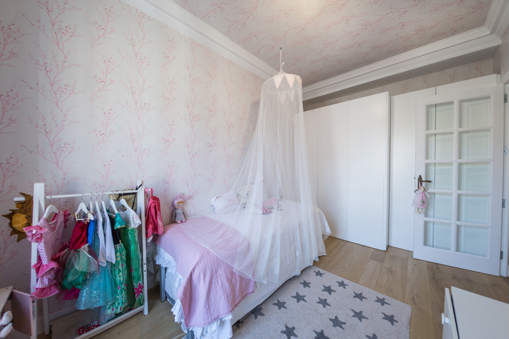 На фото: большая детская в современном стиле с спальным местом, паркетным полом среднего тона и розовыми стенами для ребенка от 4 до 10 лет, девочки