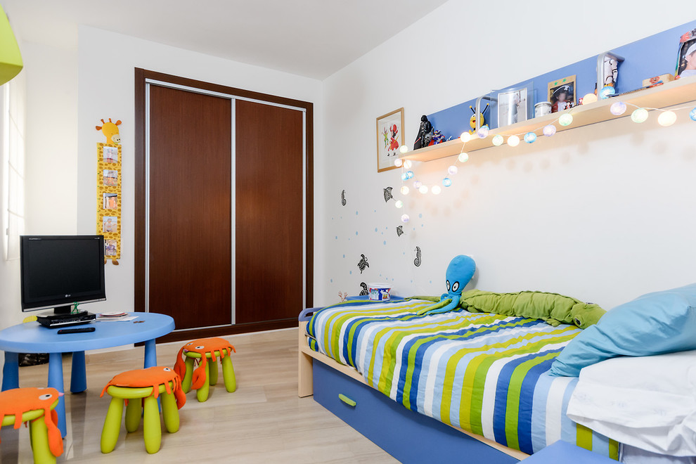 Esempio di una piccola cameretta per bambini da 4 a 10 anni scandinava con pareti bianche e parquet chiaro