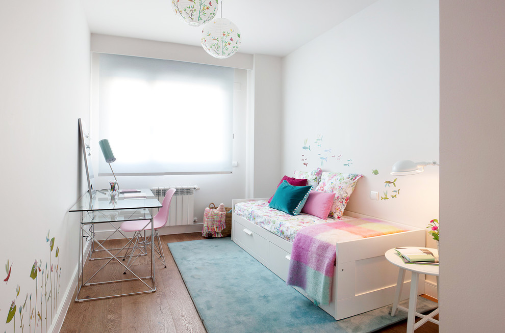 Photo of a medium sized scandi children’s room for girls in Madrid with white walls and medium hardwood flooring.