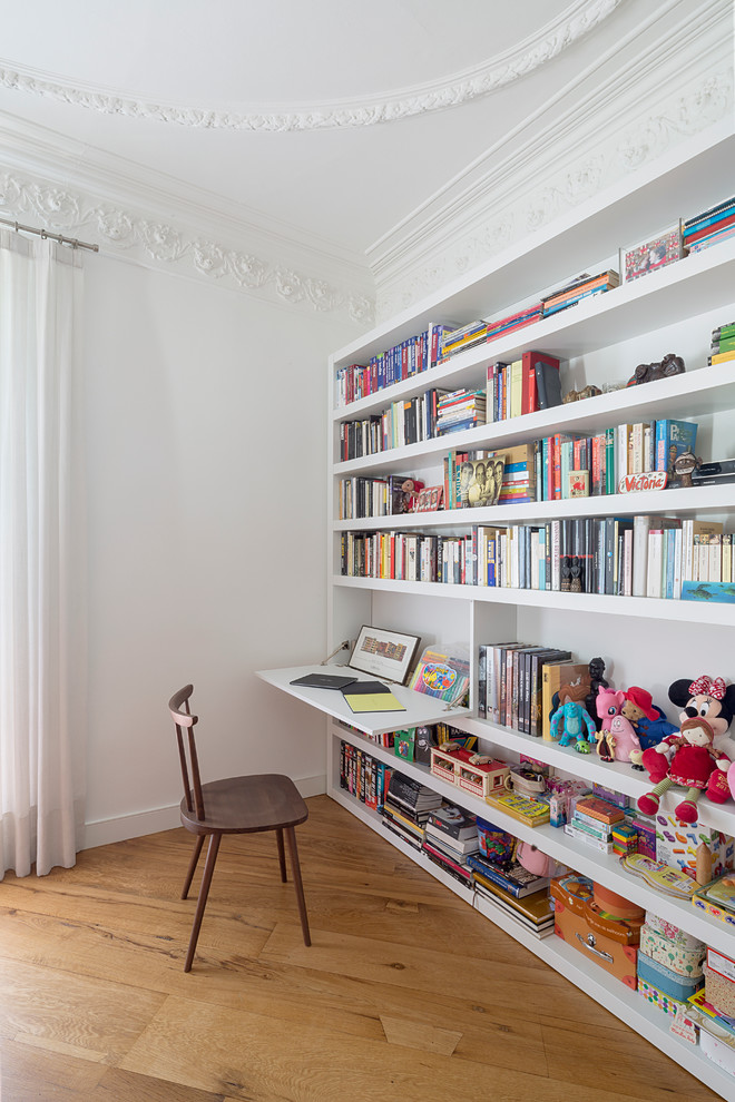 Example of a mid-sized transitional medium tone wood floor kids' room design in Barcelona with white walls