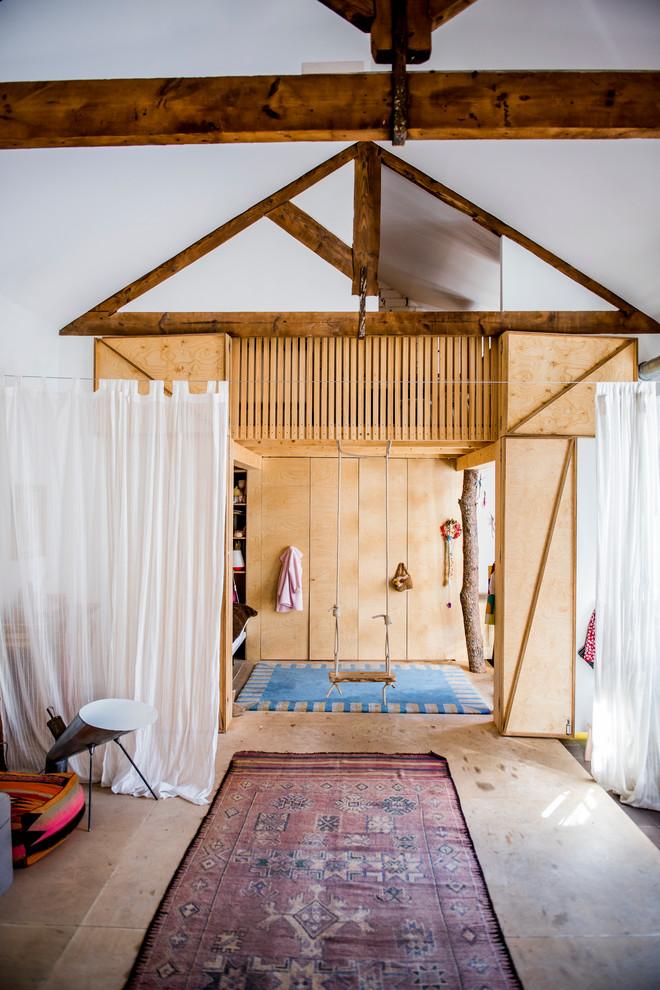 This is an example of a large eclectic gender neutral kids' bedroom in Madrid with brown walls and medium hardwood flooring.