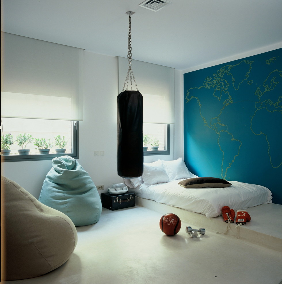 Пример оригинального дизайна: большая нейтральная детская в современном стиле с спальным местом, синими стенами и бетонным полом для подростка