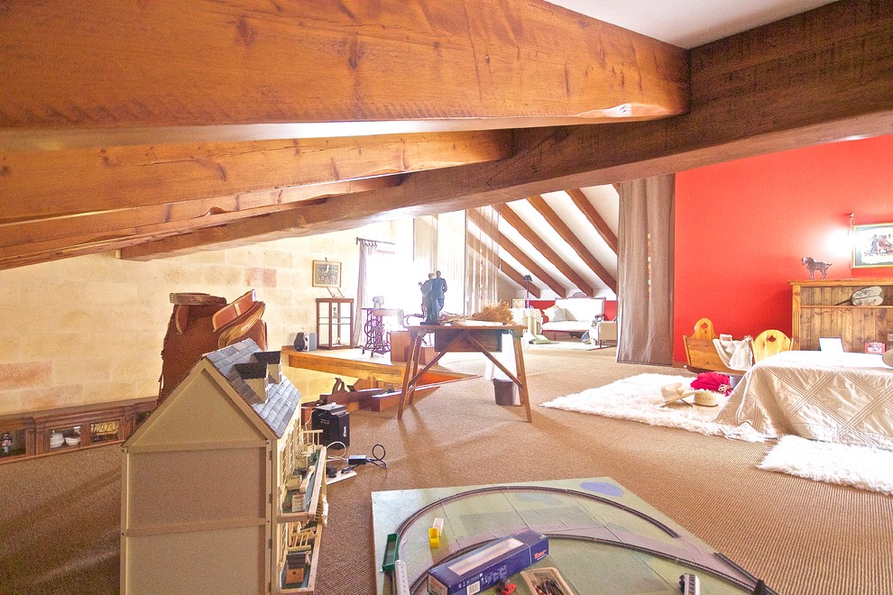 На фото: огромная нейтральная детская в стиле кантри с спальным местом, красными стенами и ковровым покрытием для ребенка от 4 до 10 лет с