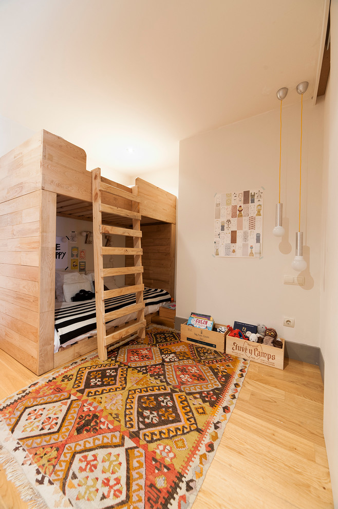 Imagen de dormitorio infantil de 4 a 10 años ecléctico de tamaño medio con suelo de madera clara y paredes blancas