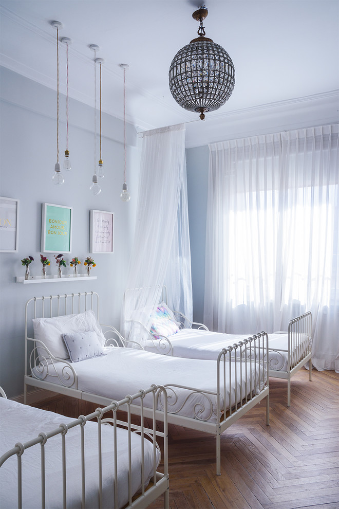 Ejemplo de dormitorio infantil de 4 a 10 años ecléctico grande con paredes azules, suelo de madera en tonos medios y suelo marrón