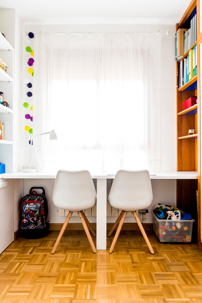 Foto di una cameretta per bambini da 4 a 10 anni contemporanea di medie dimensioni con pareti bianche e pavimento in legno massello medio
