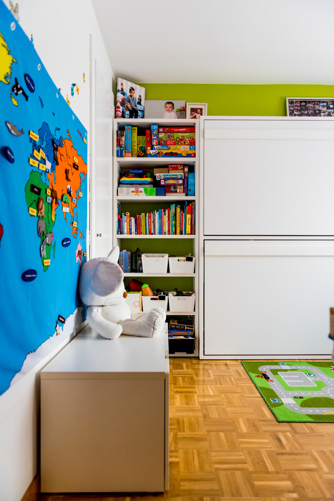 Bild på ett mellanstort funkis pojkrum kombinerat med lekrum och för 4-10-åringar, med flerfärgade väggar och mellanmörkt trägolv