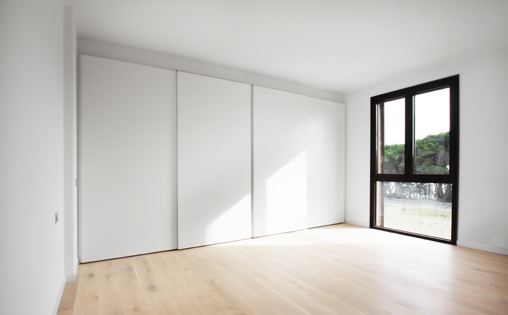 Large minimalist gender-neutral light wood floor kids' room photo in Other with white walls