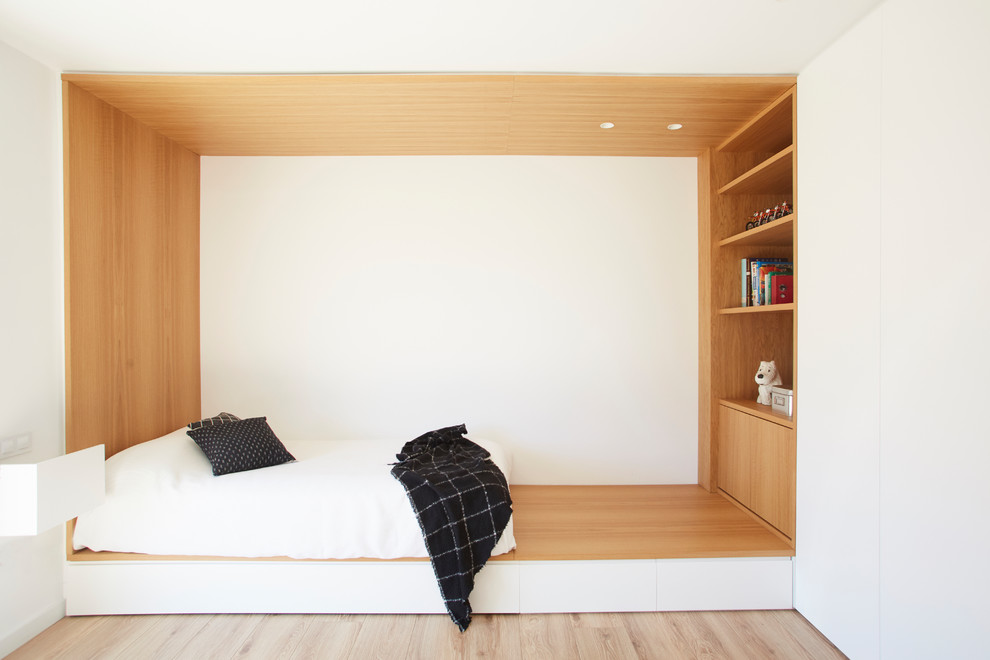Imagen de dormitorio infantil de 4 a 10 años moderno con paredes blancas, suelo de madera clara y suelo beige