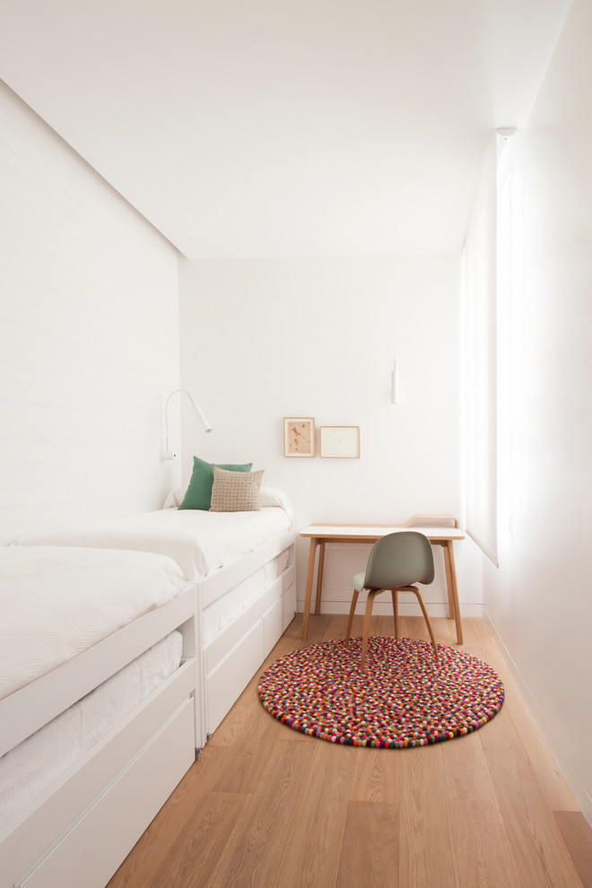 Inspiration för ett litet minimalistiskt barnrum, med vita väggar och ljust trägolv