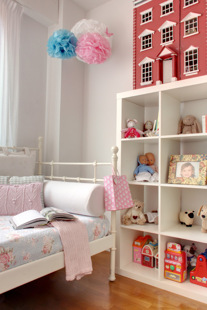 На фото: детская в классическом стиле с спальным местом, белыми стенами и паркетным полом среднего тона для ребенка от 4 до 10 лет, девочки